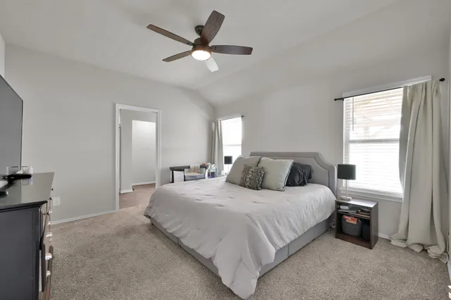 a bedroom with a large bed and a chandelier