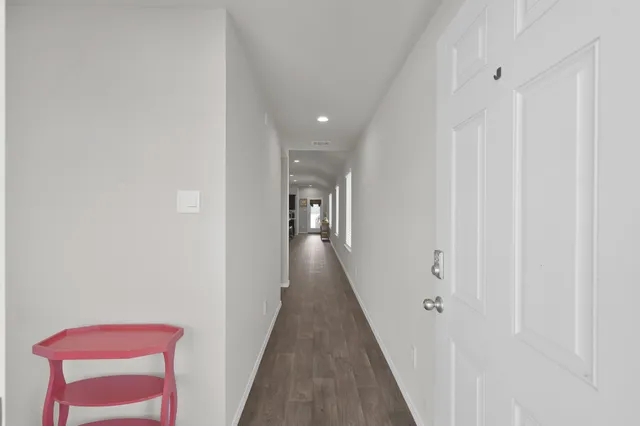 a view of a hallway with wooden floor and staircase