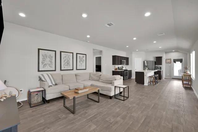 a living room with furniture and a wooden floor