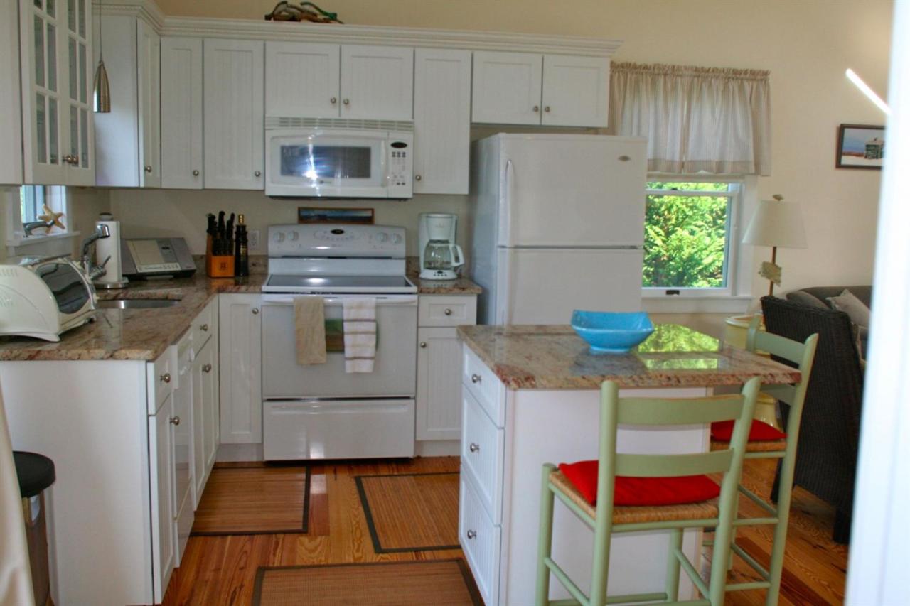 6 Shore Road, Unit 7 Truro, MA 02666 - Photo 3 of 12 a kitchen with stainless steel appliances granite countertop a refrigerator sink stove and white cabinets