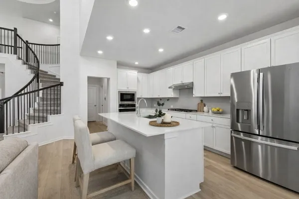 a kitchen with refrigerator and chairs