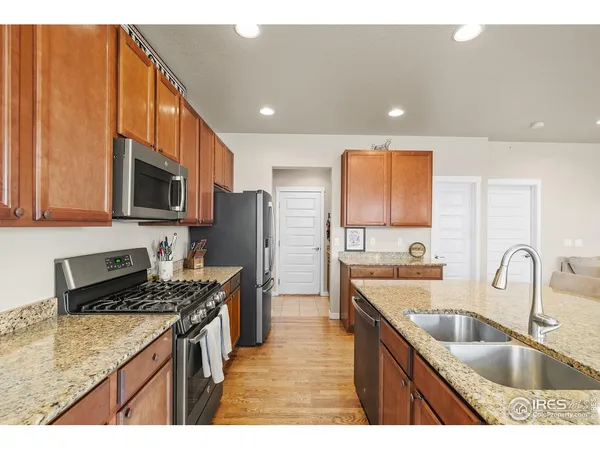 a kitchen with kitchen island granite countertop a sink stove refrigerator and cabinets