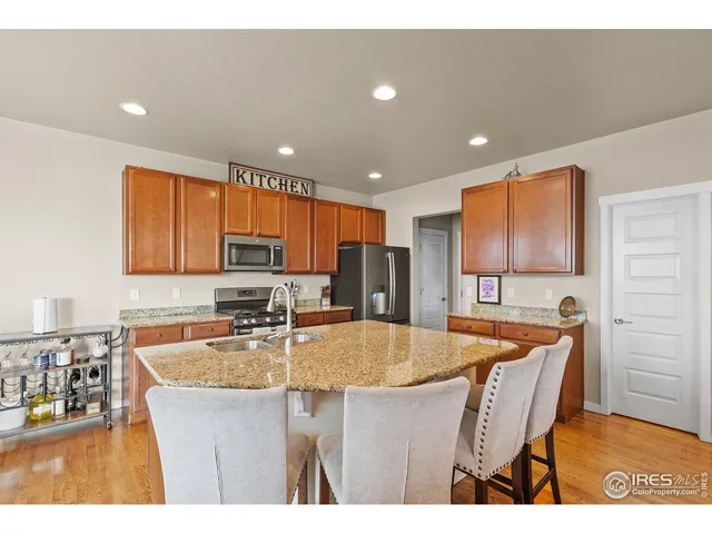 a kitchen with stainless steel appliances granite countertop a sink counter space and a refrigerator