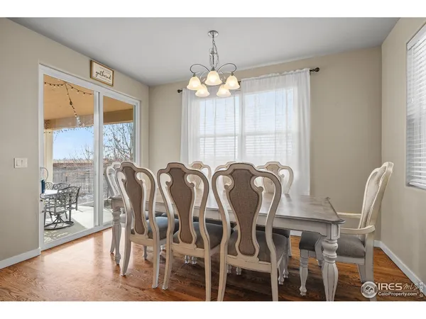 a view of a dining room with furniture a chandelier and wooden floor