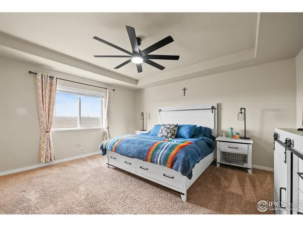 a bedroom with a bed and a ceiling fan