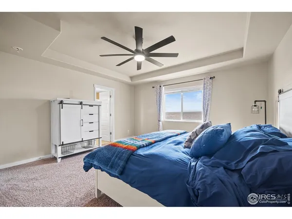a bedroom with a bed and a ceiling fan