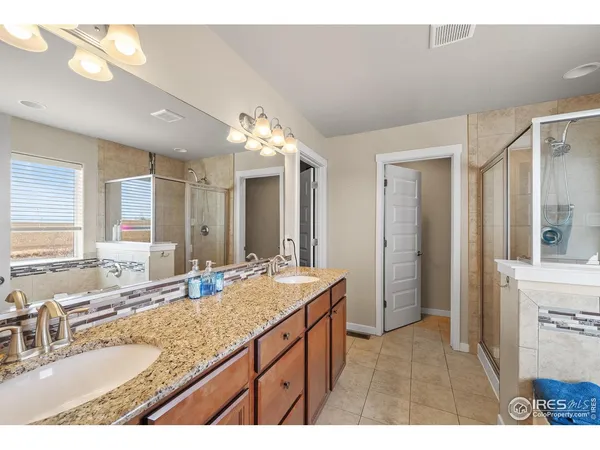 a bathroom with a sink double vanity granite and a mirror