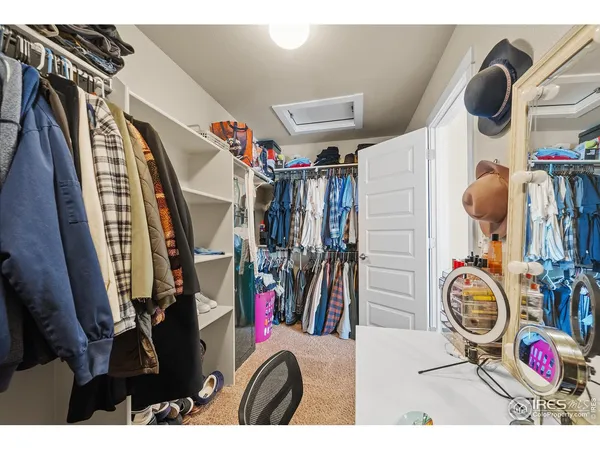a view of walk in closet with clothes shoes and a washer dryer