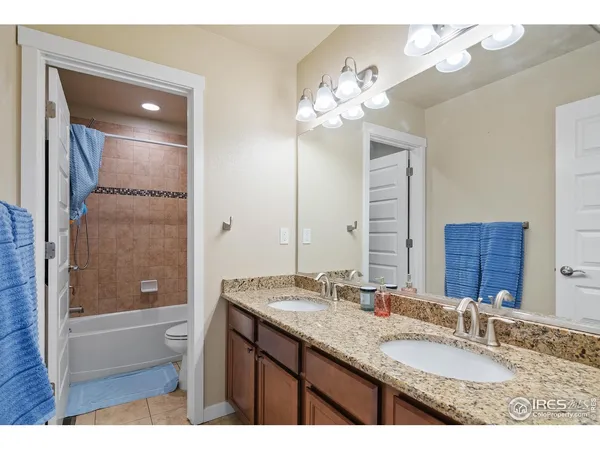 a bathroom with a granite countertop sink a large mirror and a bathtub