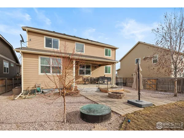 a backyard of a house with fire pit and chairs