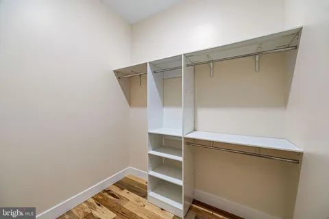 a view of walk in closet with clothes and shoes