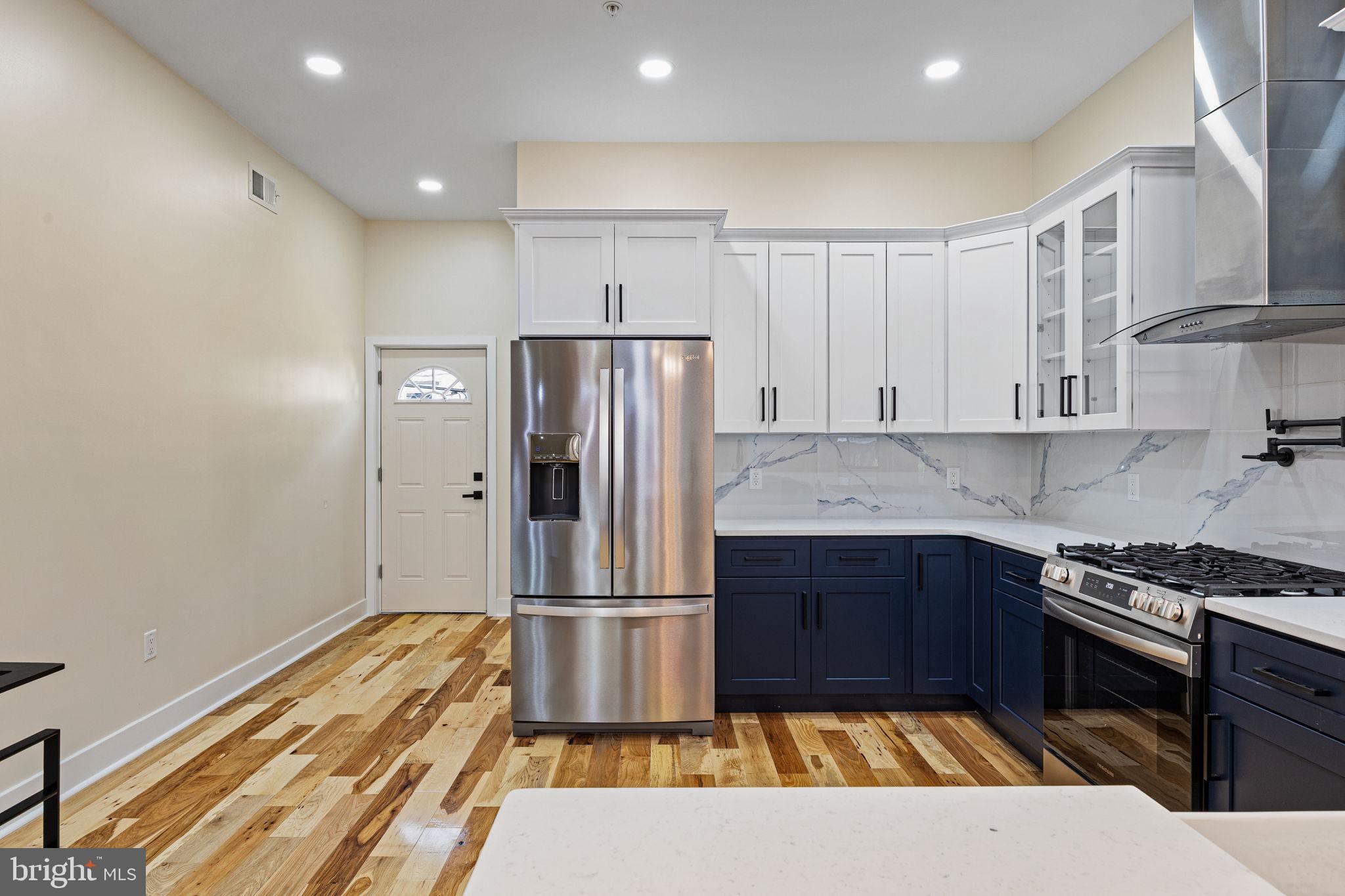 272 South Frazier Street Philadelphia, PA 19139 - Photo 8 of 34 a kitchen with kitchen island wooden cabinets and stainless steel appliances