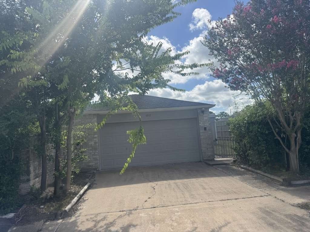11807 South Youngwood Lane Houston, TX 77043 - Photo 1 of 13 a view of a house with a yard and garage