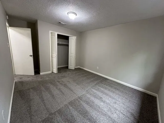 an empty room with closet and a window