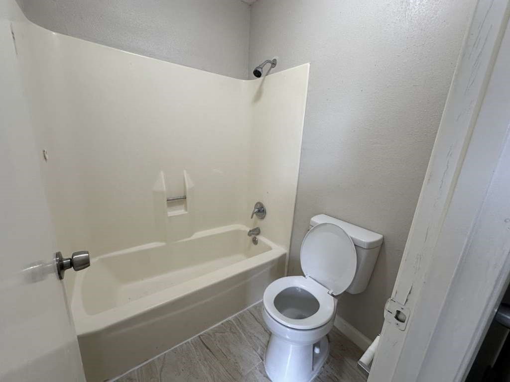 11807 South Youngwood Lane Houston, TX 77043 - Photo 9 of 13 a bathroom with a toilet and a tub