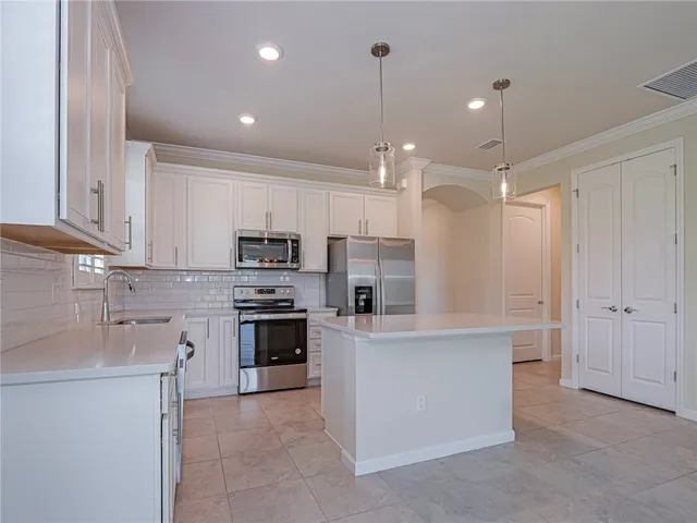a kitchen with kitchen island a sink stainless steel appliances and cabinets