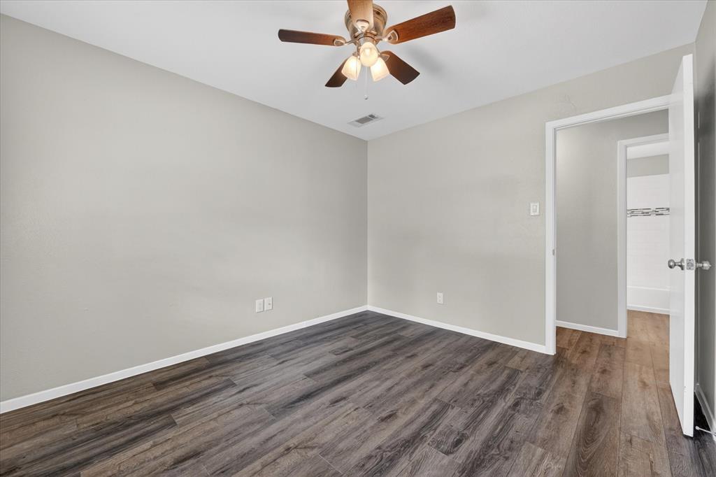 205 Wayne Street Sanger, TX 76266 - Photo 19 of 29 a view of a room with wooden floor and a ceiling fan