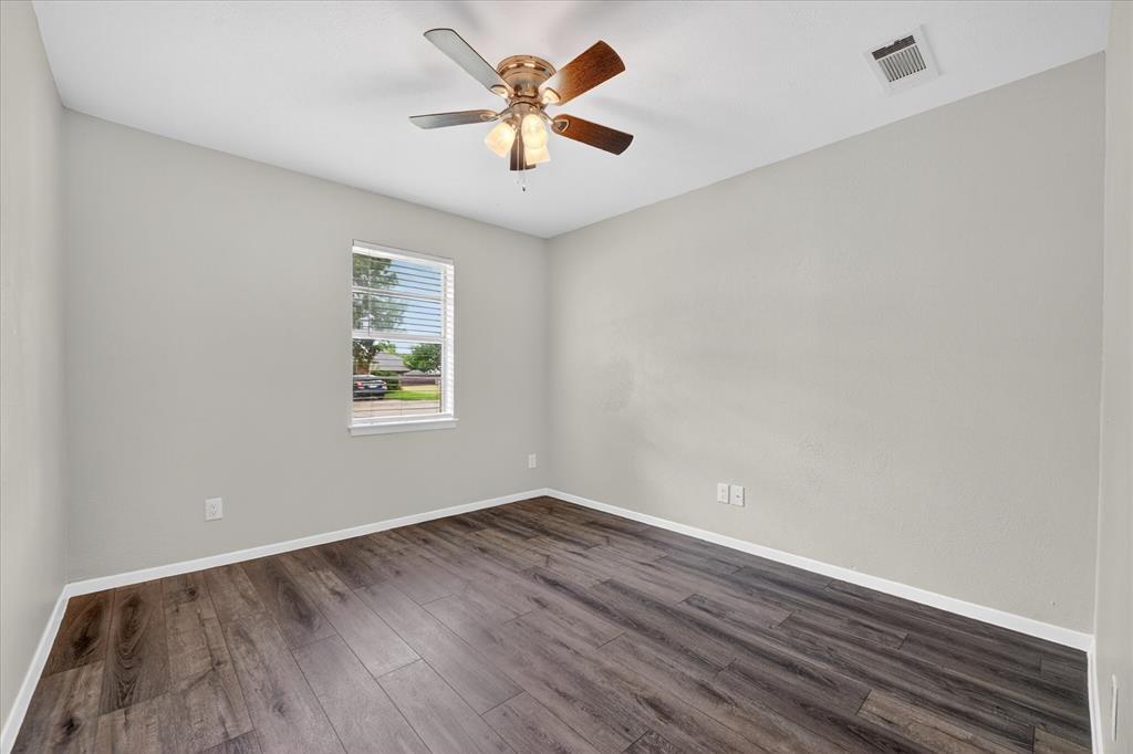 205 Wayne Street Sanger, TX 76266 - Photo 20 of 29 an empty room with wooden floor and windows