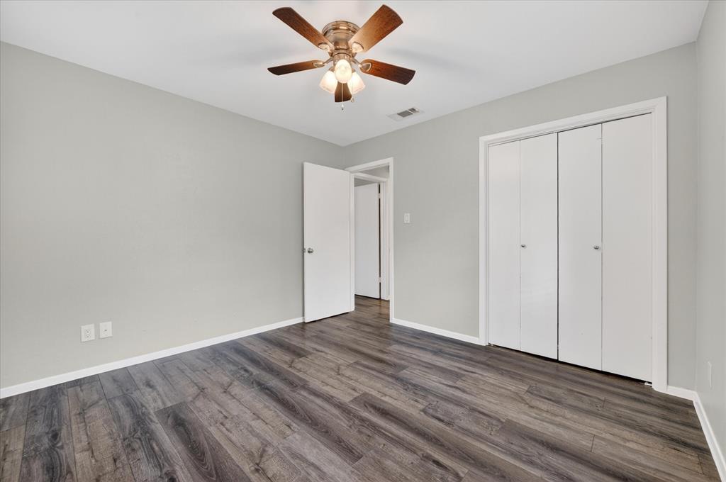 205 Wayne Street Sanger, TX 76266 - Photo 24 of 29 a view of a room with wooden floor and a ceiling fan