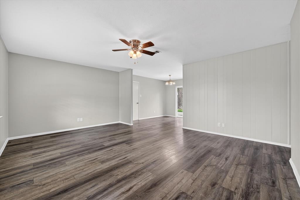 205 Wayne Street Sanger, TX 76266 - Photo 9 of 29 a view of an empty room with wooden floor and ceiling fan