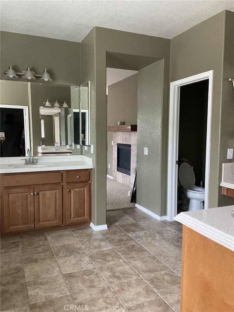 9503 Orleans Lane Riverside, CA 92508 - Photo 19 of 28 a spacious bathroom with a granite countertop sink and a mirror