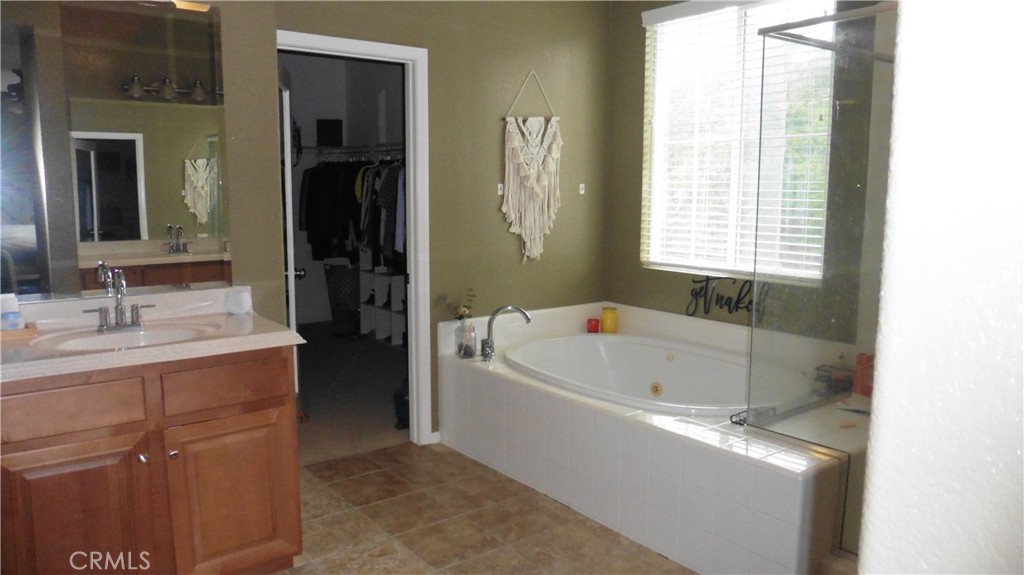 9503 Orleans Lane Riverside, CA 92508 - Photo 20 of 28 a bathroom with a tub sink and mirror