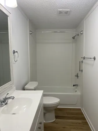 a bathroom with a sink a toilet and shower