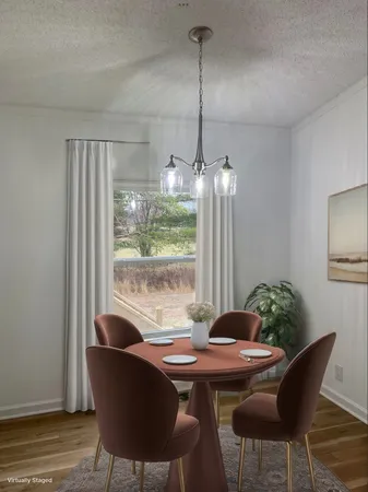 a dining room with furniture a chandelier and wooden floor