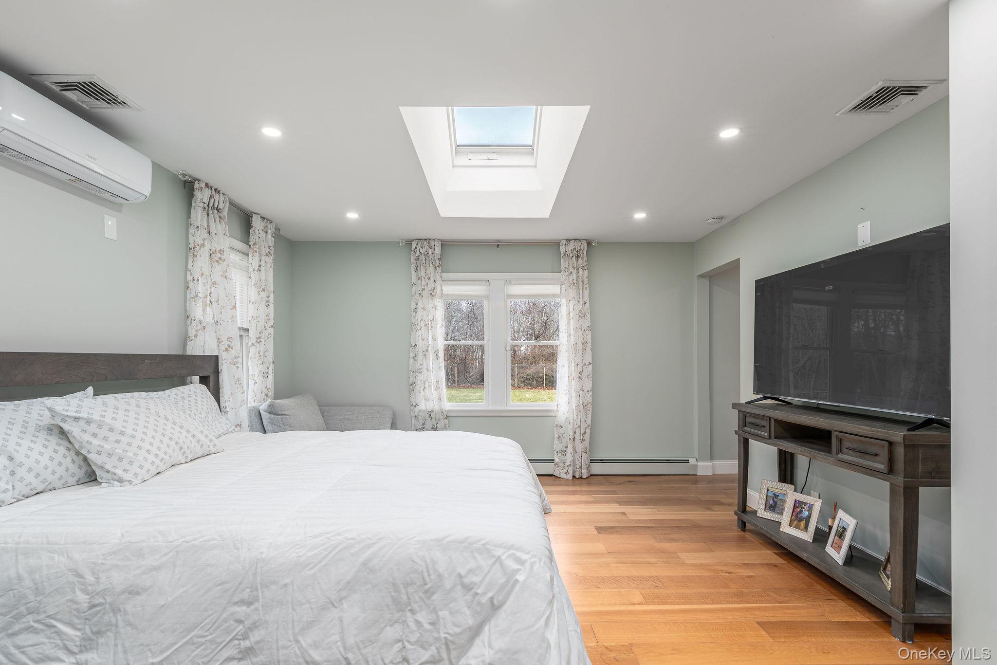 10940 Main Road East Marion, NY 11939 - Photo 17 of 38 a spacious bedroom with a bed and a television