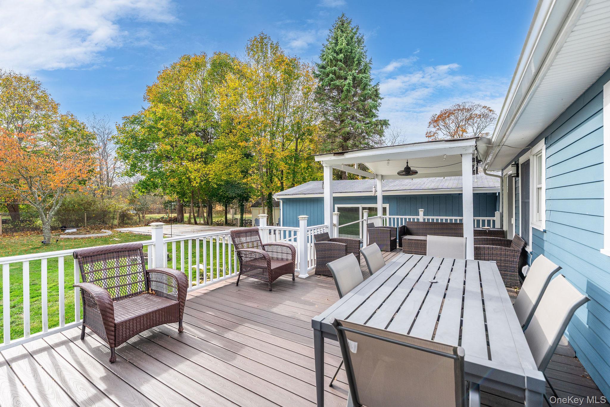 10940 Main Road East Marion, NY 11939 - Photo 23 of 38 a view of a patio with table and chairs with wooden floor and fence