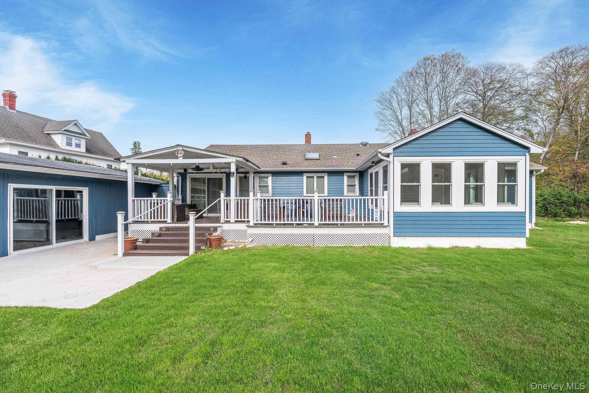10940 Main Road East Marion, NY 11939 - Photo 25 of 38 a view of a house with a deck and a yard