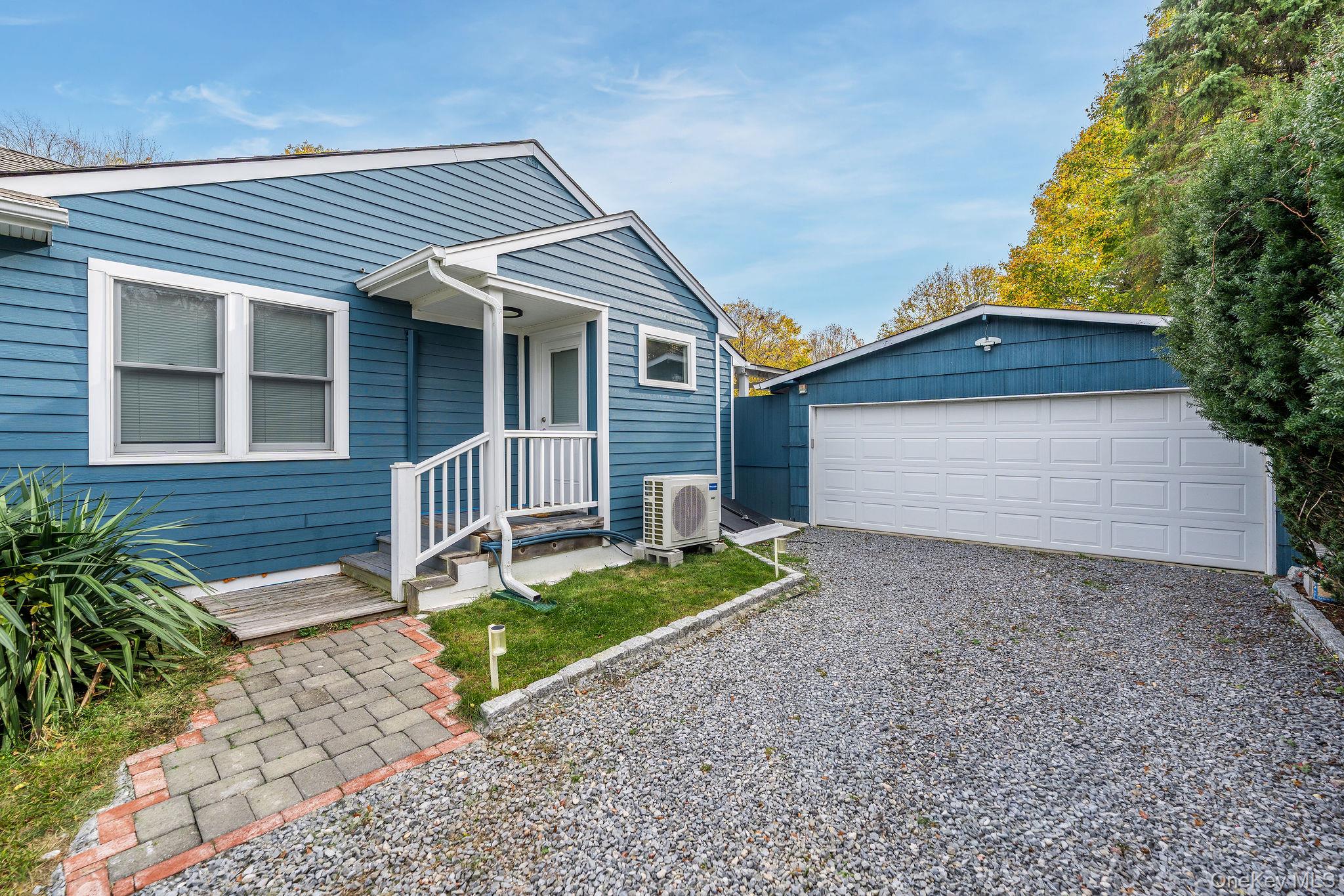 10940 Main Road East Marion, NY 11939 - Photo 32 of 38 a front view of a house with a yard and garage