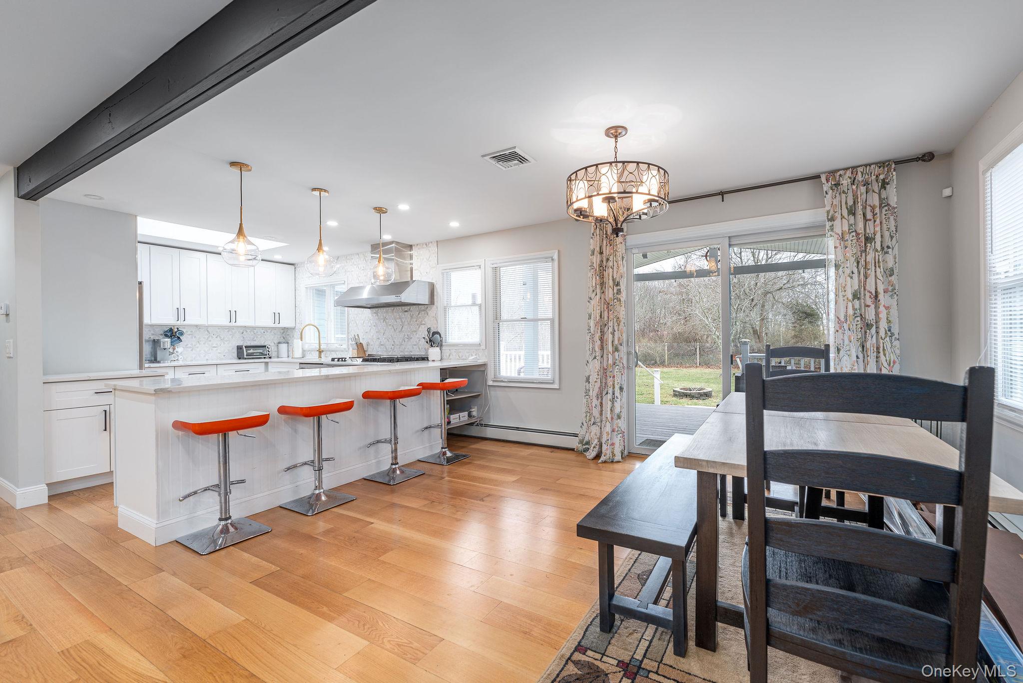 10940 Main Road East Marion, NY 11939 - Photo 5 of 38 a living room with furniture a rug and a chandelier