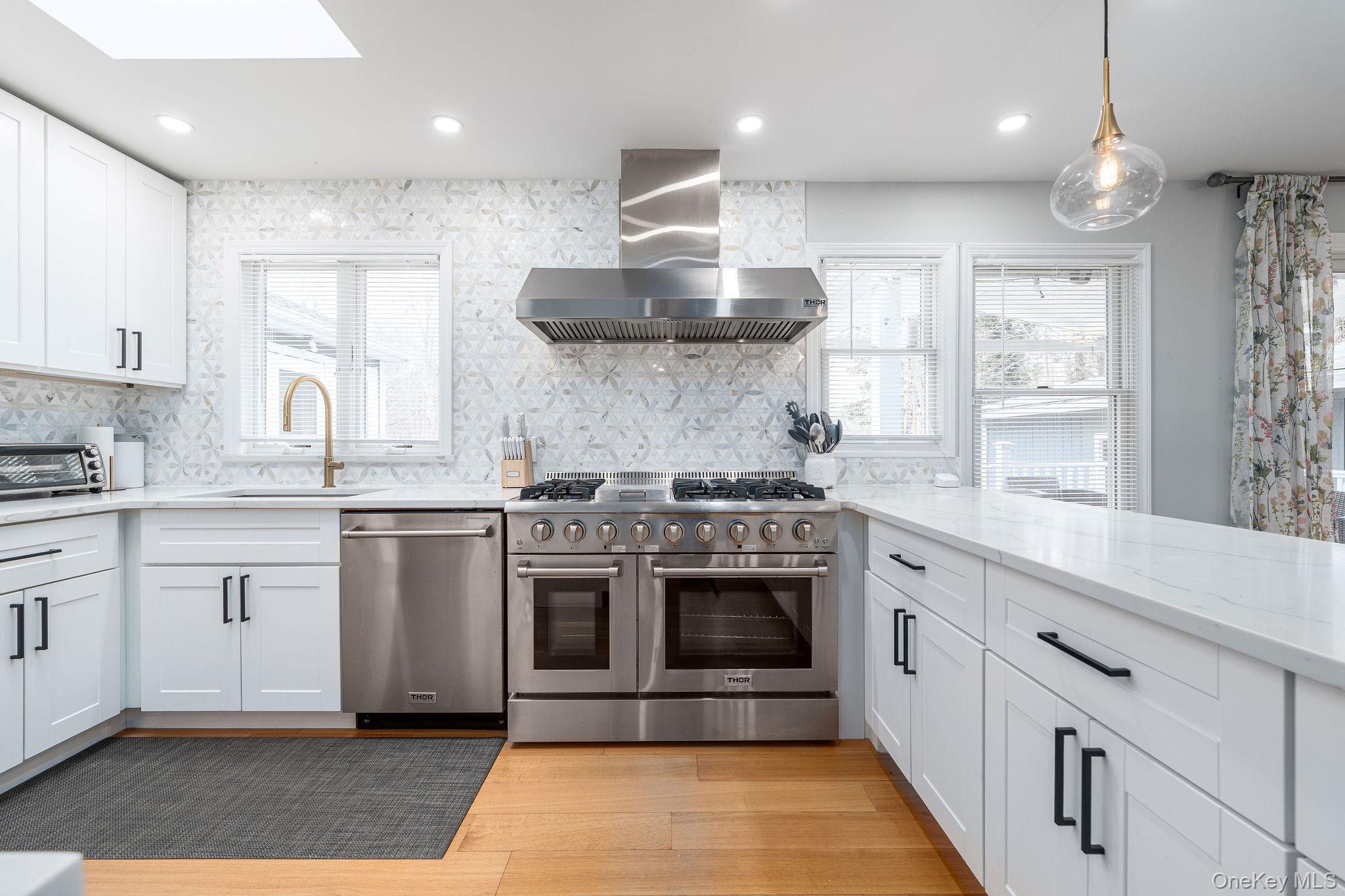10940 Main Road East Marion, NY 11939 - Photo 7 of 38 a large kitchen with stainless steel appliances granite countertop a stove a sink and a microwave