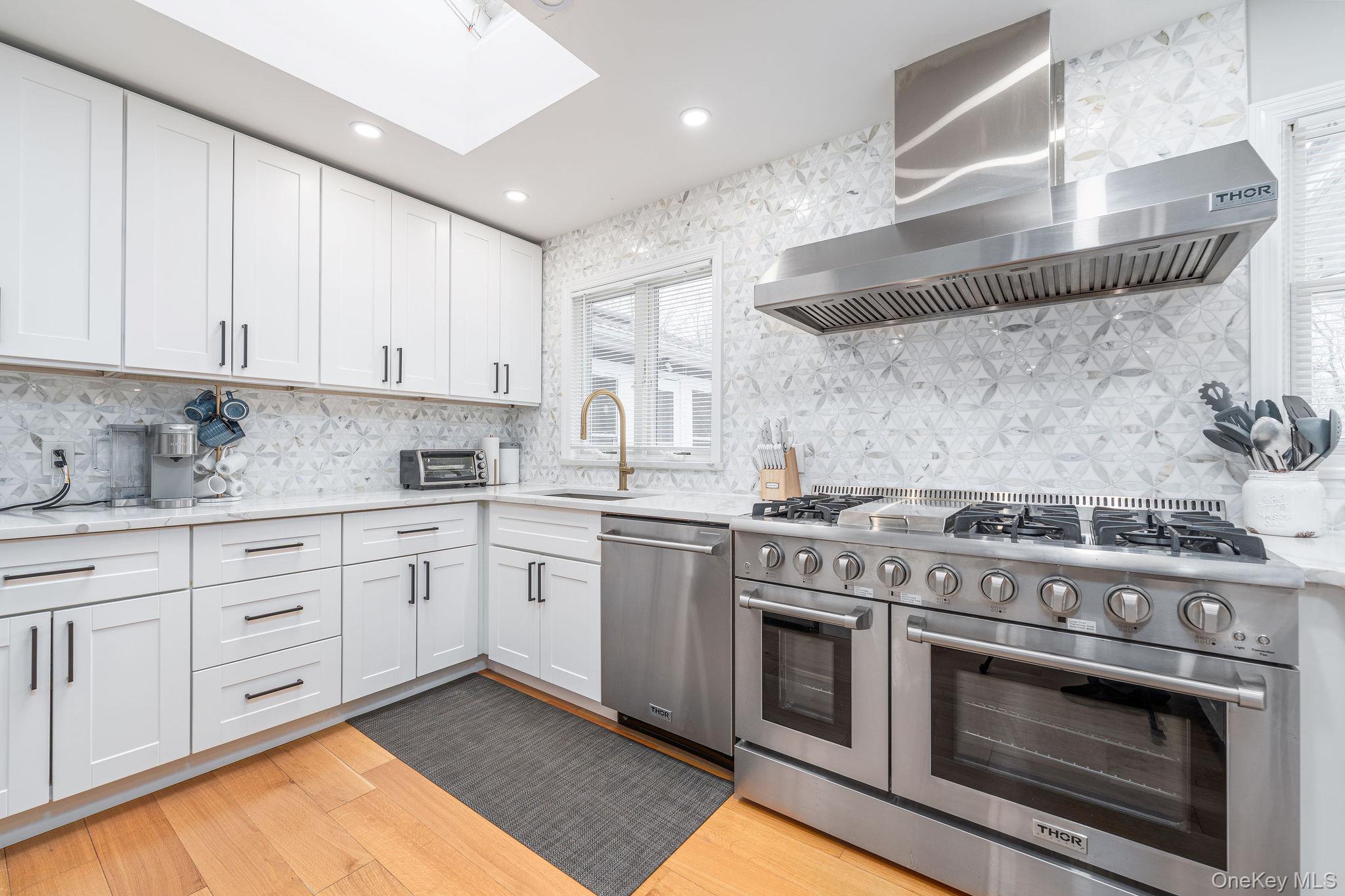 10940 Main Road East Marion, NY 11939 - Photo 8 of 38 a kitchen with stainless steel appliances granite countertop a stove and white cabinets