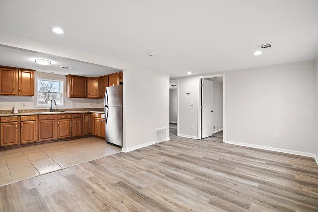 a view of kitchen with stainless steel appliances granite countertop a stove a sink and a refrigerator