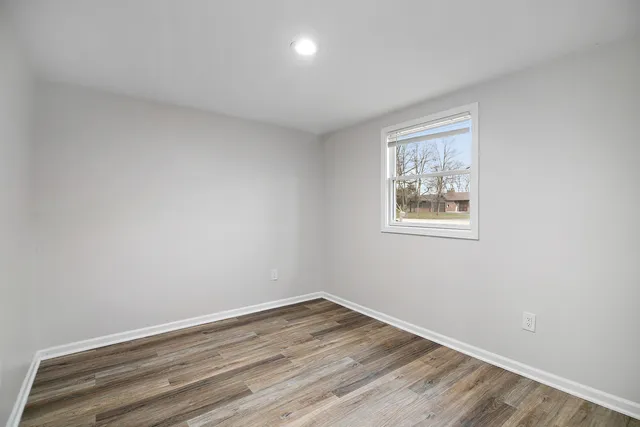 a view of empty room with wooden floor