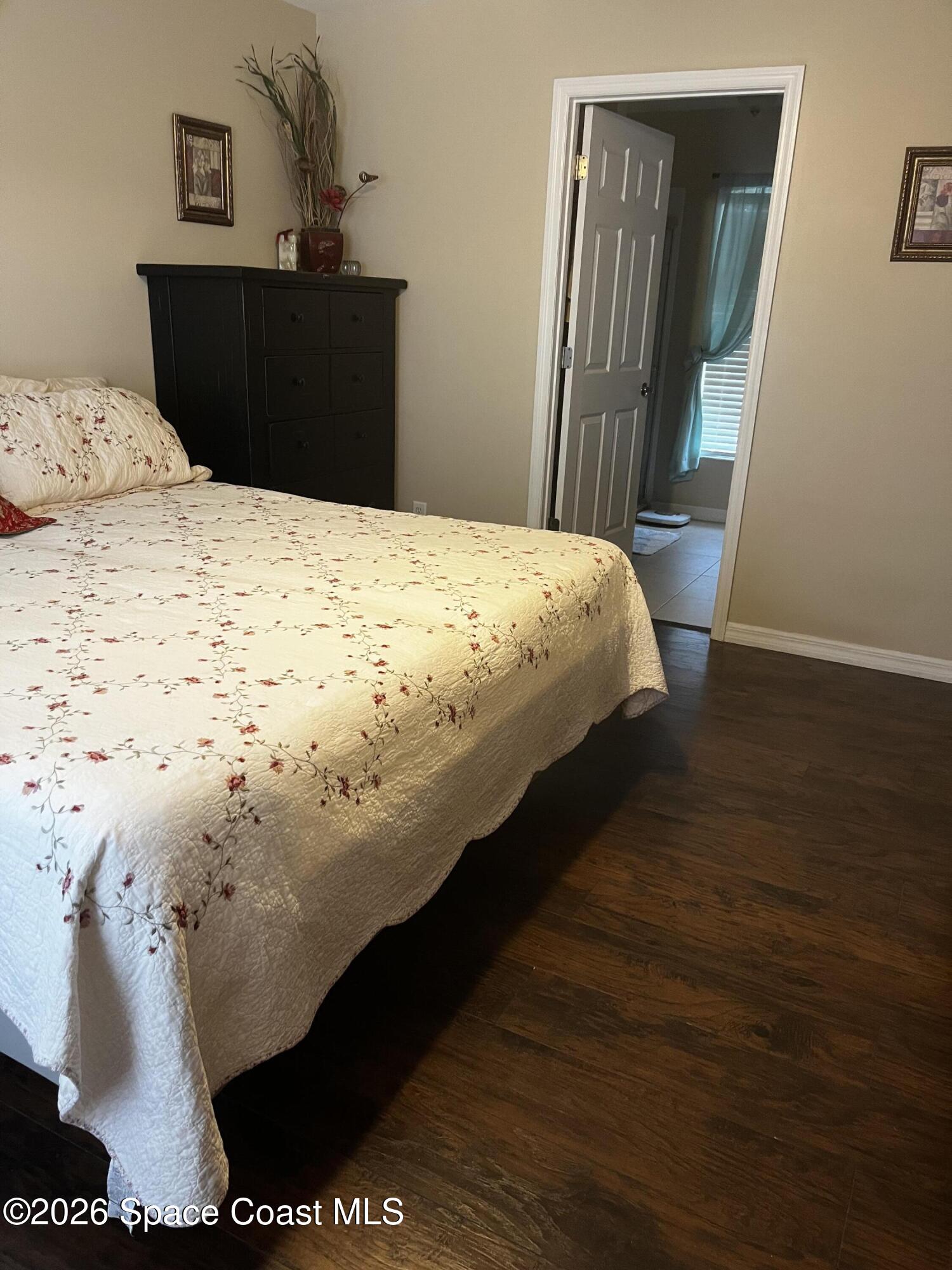1219 Walnut Grove Way Rockledge, FL 32955 - Photo 12 of 23 a bed sitting in a bedroom next to a wooden floor