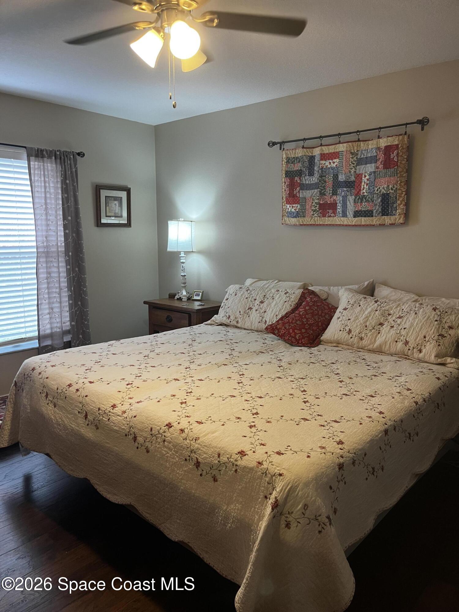 1219 Walnut Grove Way Rockledge, FL 32955 - Photo 13 of 23 a bedroom with a bed and a chandelier