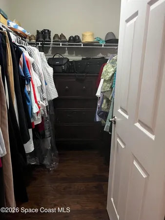 a view of walk in closet with clothes and shoes