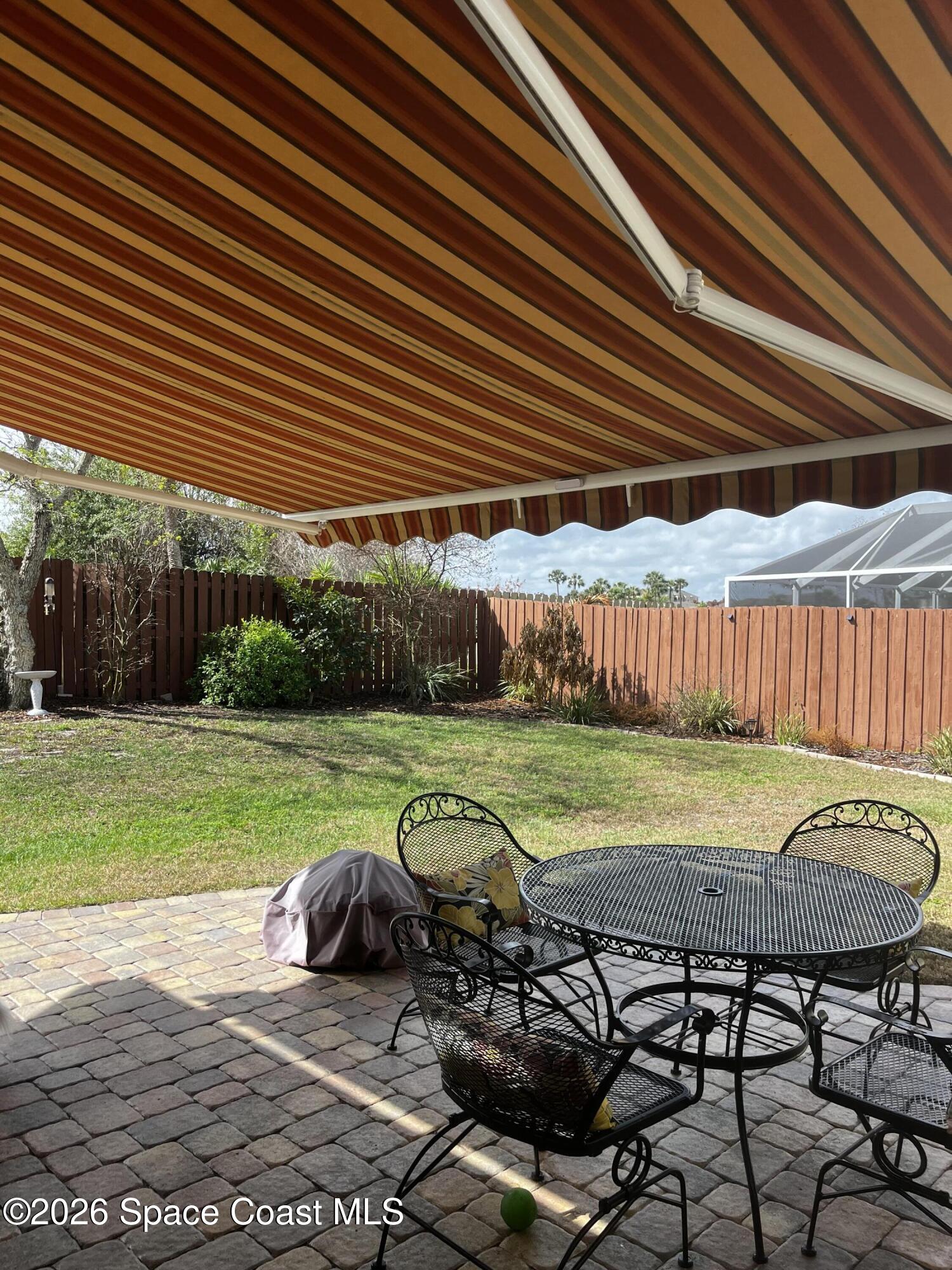 1219 Walnut Grove Way Rockledge, FL 32955 - Photo 20 of 23 a view of a backyard with table and chairs under an umbrella
