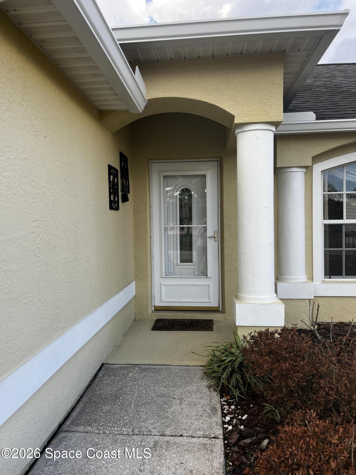 1219 Walnut Grove Way Rockledge, FL 32955 - Photo 2 of 23 a front view of a house with a yard