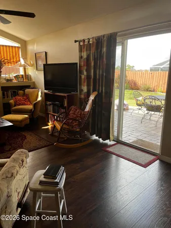 a living room with furniture a flat screen tv and a large window