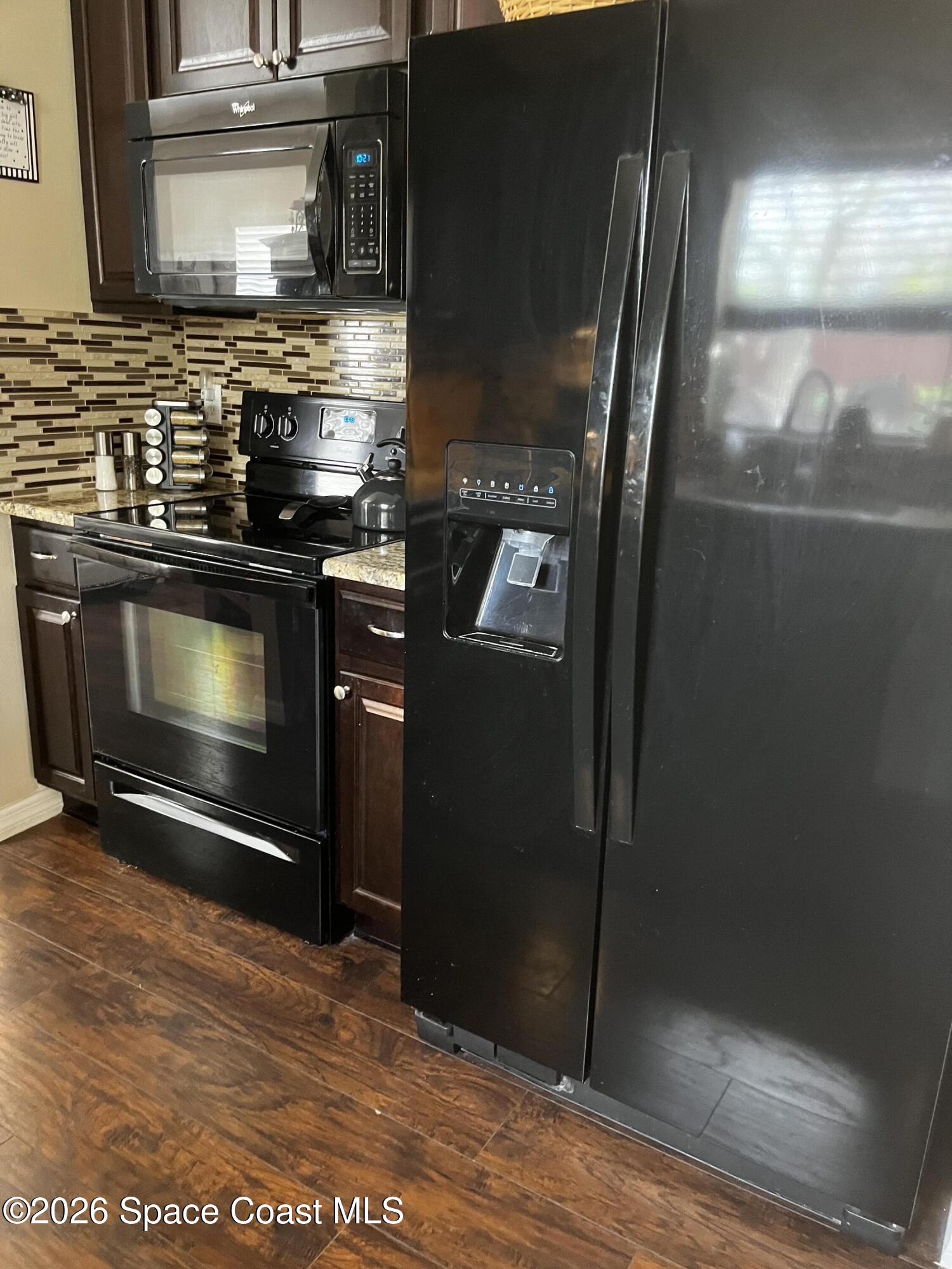 1219 Walnut Grove Way Rockledge, FL 32955 - Photo 8 of 23 a kitchen with stainless steel appliances wooden cabinets and a stove