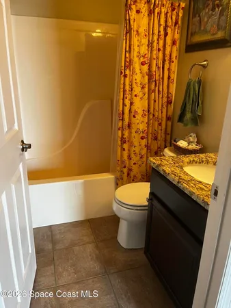 a bathroom with a granite countertop bathtub shower sink and toilet