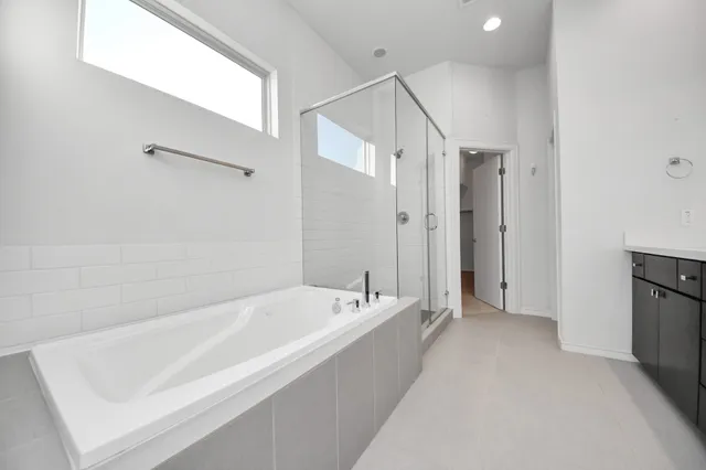 a spacious bathroom with a double vanity sink a mirror and a bathtub