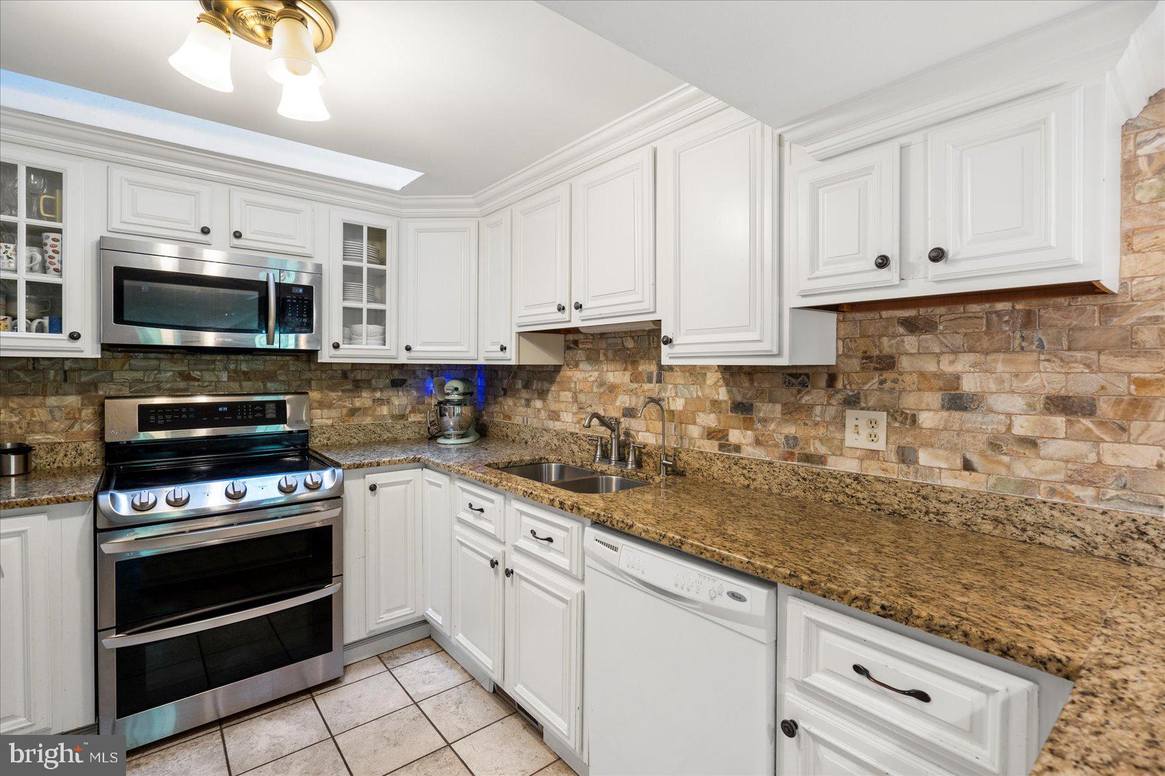 972 Bird River Beach Road Middle River, MD 21220 - Photo 12 of 50 a kitchen with granite countertop a stove a sink and a microwave