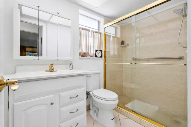 a bathroom with a shower sink vanity and toilet