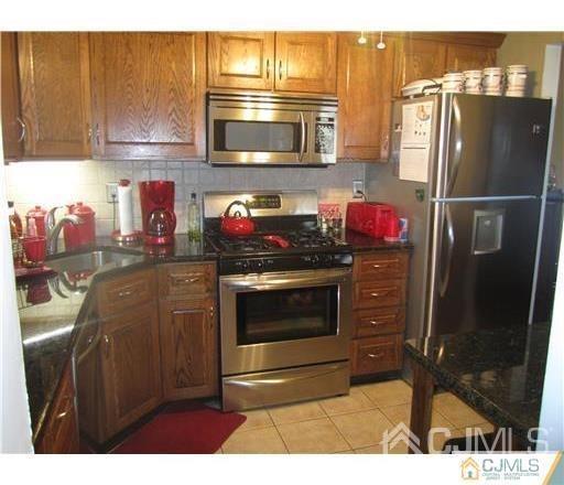 310 Raintree Court Helmetta, NJ 08828 - Photo 4 of 8 a kitchen with stainless steel appliances kitchen island granite countertop a refrigerator stove and microwave
