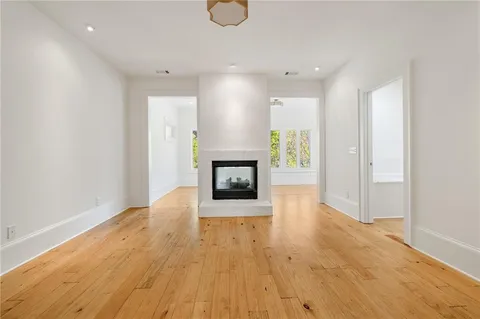 an empty room with wooden floor and fireplace